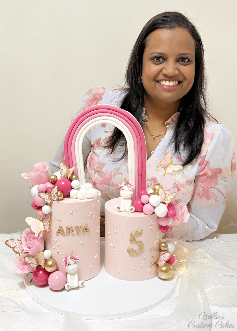 2 cakes connected by a rainbow in pink