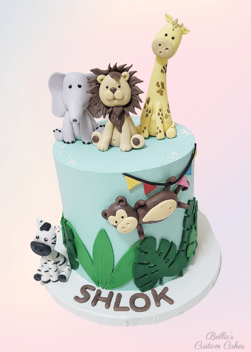Cake decorated with wild animals like elephant, lion, and giraffe