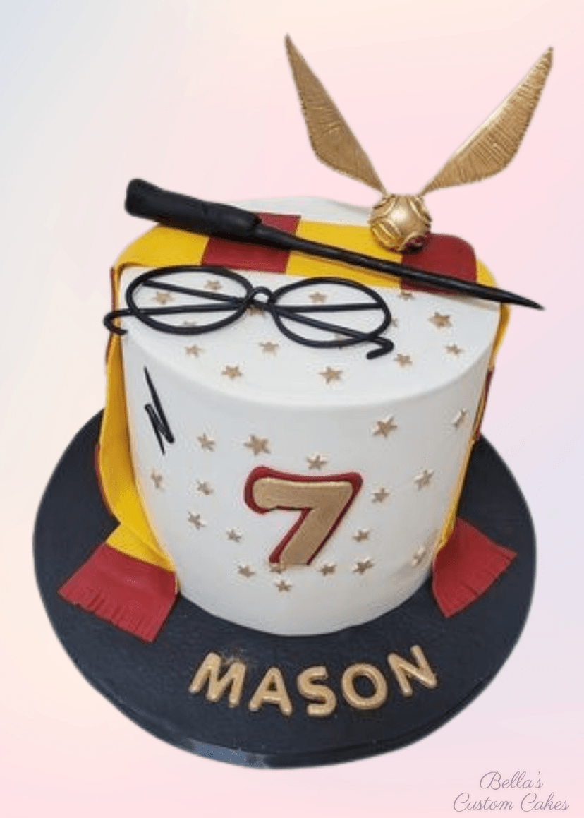 Harry Potter themed cake featuring the Hogwarts crest and wand