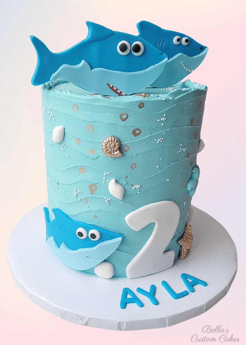 Pastel-colored cake with shark and coral accents