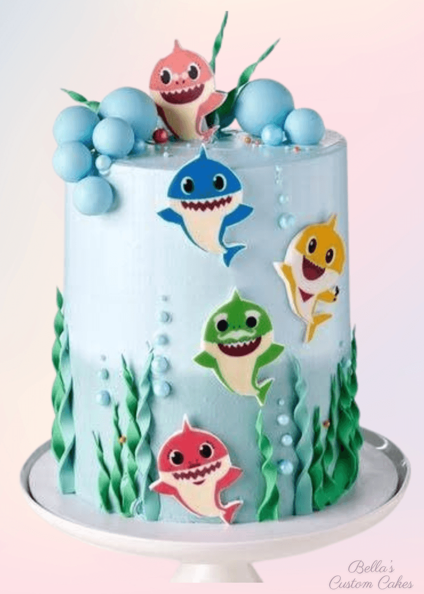 Shark-themed cake with blue ocean waves and a 3D shark topper